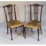 A pair of Victorian ebonised mahogany salon chairs, each with scroll comb back top rails, above