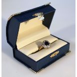 A diamond and sapphire floral cluster ring, with claw set central sapphire surrounded by small