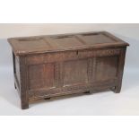 A 17thC oak coffer, the three panelled moulded lid hinging to reveal a plain interior with candle