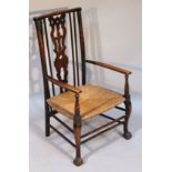 An early 20thC rush seated child's chair, with a pierced back splat, surmounted by a comb shape