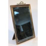 A George V silver framed table mirror, of rectangular form headed by a ribbon and scroll finial with
