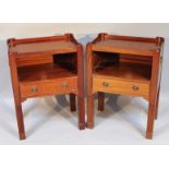 A pair of bedside cabinets, each in plum pudding mahogany of shaped rectangular form, with galleried