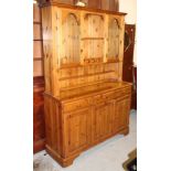 A Ducal stripped and lightly polished pine dresser, the upper section with open shelves flanked by