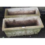 A pair of stone planters, each of shaped rectangular tapering form with textured bodies, of 20thC