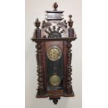 An early 20thC walnut cased wall clock, the 15cm dia. dial fitted in a three glazed cased flanked by