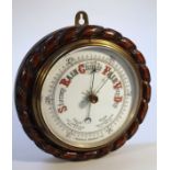 An early 20thC oak cased wall aneroid barometer, with a rope twist case and 16cm dial.
