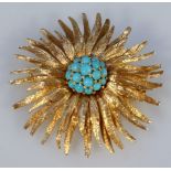 An Art Deco design sun burst brooch, centred with raised turquoise, of shaped form with a plain pin