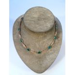 A necklace, set with jade with a plain circular clasp end, marked 9ct, 15.1g all in, 40cm long,