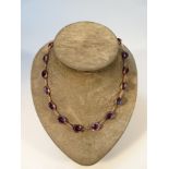 A 19thC amethyst necklace, set with 14 faceted cut stones, each claw set and broken by a chain link