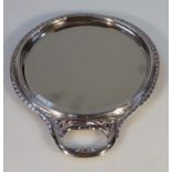 A Victorian silver hand mirror, probably by William Comyns, of circular form with a pierced handle,