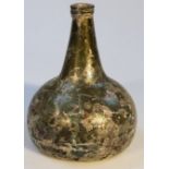 An early 18thC opalescent green glass bottle, of onion shaped form with circular stem and concave