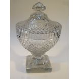 A cut glass jar and cover, of circular hobnail cut form, the dome top with floral knop, the whole on