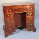 A principally George III flamed mahogany kneehole desk, the moulded top with canted front corners
