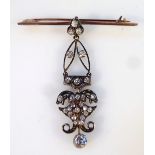 A late Victorian diamond drop pendant, surmounted by a cloverleaf top, above pierced floral mounts,
