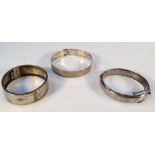 Three various Victorian and later bangles, to include engine turned examples, 7cm wide, and two