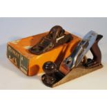 A Stanley wood plane, with wooden and metal mounts, 15cm high, and a flat plane in part box. (2)