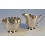 An early 20thC Irish silver milk jug and sugar bowl, by Wakely & Wheeler, each with flared rims and