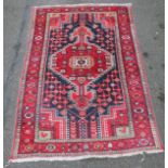 An Iranian rug, of rectangular geometric pattern in red, blue and orange, 125cm x 93cm.