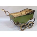 An early 20thC child's pram, the shaped frame painted green with articulated canopy on four rubber