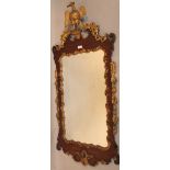 A George III mahogany and parcel gilt wall mirror, the rectangular glass held in a elaborate gilt