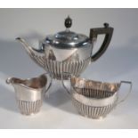 A George V silver tea service, by William Hutton, comprising part gadrooned teapot with ebonised