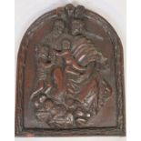 An oak arched panel, relief carved with cherubs and figures before lamb with a bell flower border