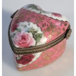 An OC & Co enamel heart shaped pill box, with gilt and ormalou mounts decorated with roses on a pink