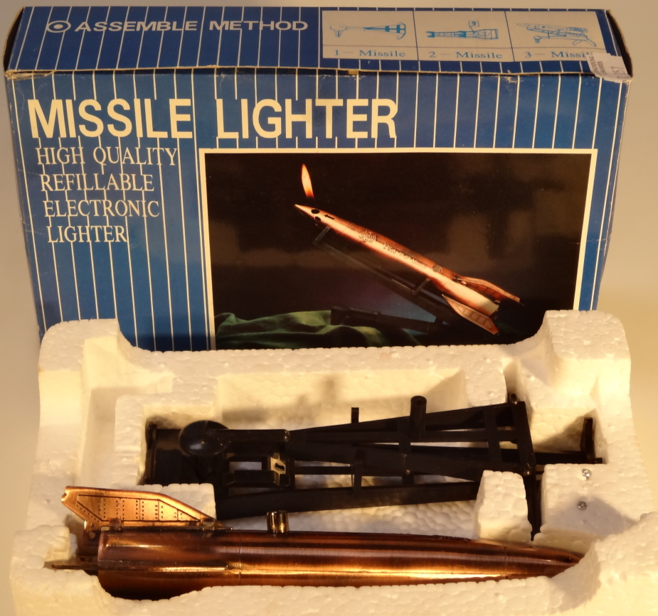 A 1PCS Missile cigarette lighter, on stand, boxed, 12cm wide.