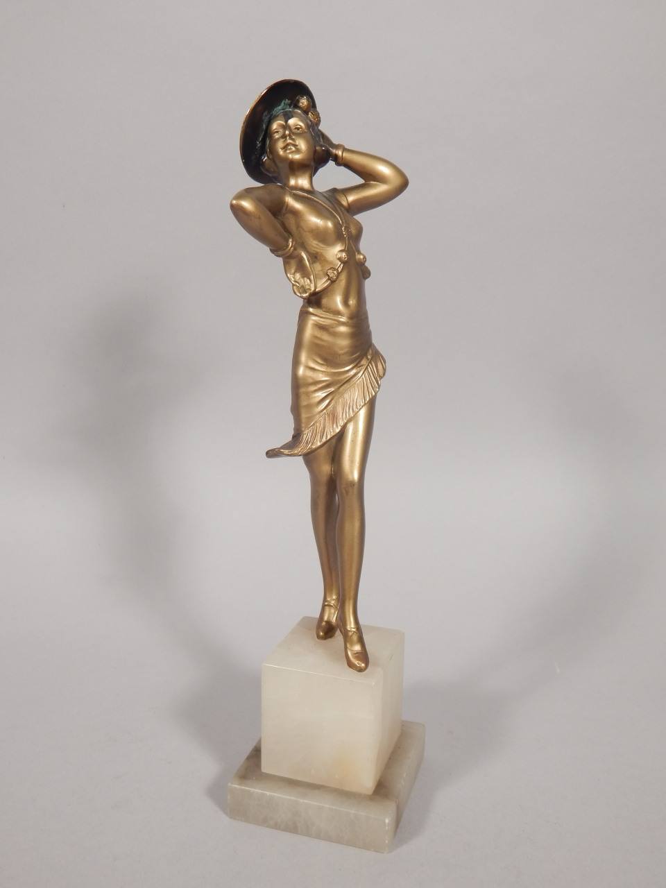An Art Deco cold painted bronze figure of female dancer, wearing a Spanish style hat, on a stepped