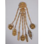 A late 19thC gilt metal chatelaine, elaborately cast in rococo style, the seven chains attached with