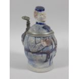 An unusual late 19thC German stoneware lidded tankard, in the form of a gentleman wearing a small