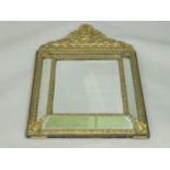 A 19thC Continental cushion shaped mirror, the elaborate brass frame decorated with leaves and