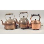 Three 20thC copper electric kettles, each with a turned wood or Bakelite handle, on small feet