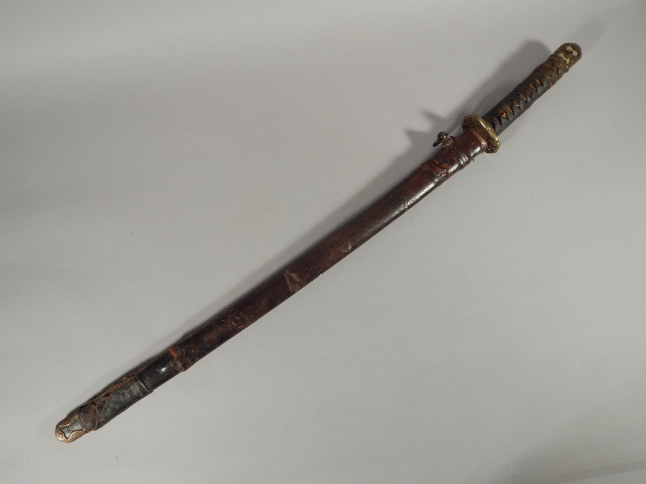 A Japanese World War II Officer's samurai sword, with bronze mounts and pierced brass tsuba, the