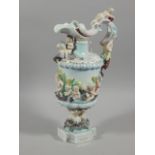 A late 19th/early 20thC Capodimonte style porcelain ewer, cast overall with putti, picked out in