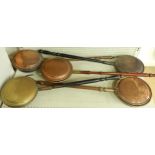 Five copper and brass warming pans, each with turned handles, four with engraved designs to the