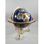 A modern globe, inset in semi precious stones, on a brass stand with compass, the globe 30cm
