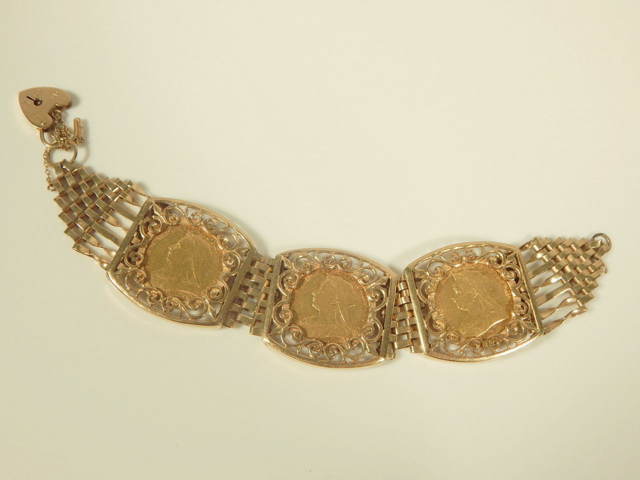 A triple sovereign bracelet, set with three full gold sovereigns, dated 1900, 1899, and 1897, with