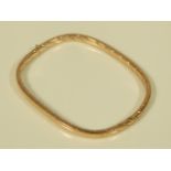 A 9ct gold hinged bangle, of rectangular form, with reeded bands, hollow, 8g all in.