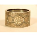 A silver bangle, decorated with flowers in copper and brass, 41g all in.