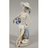 A Lladro porcelain figure of a girl, sat on a rock at the beach, 21cm high (boxed)