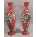 A pair of Victorian opaque and red overlay glass vases, each decorated in raised coloured enamels