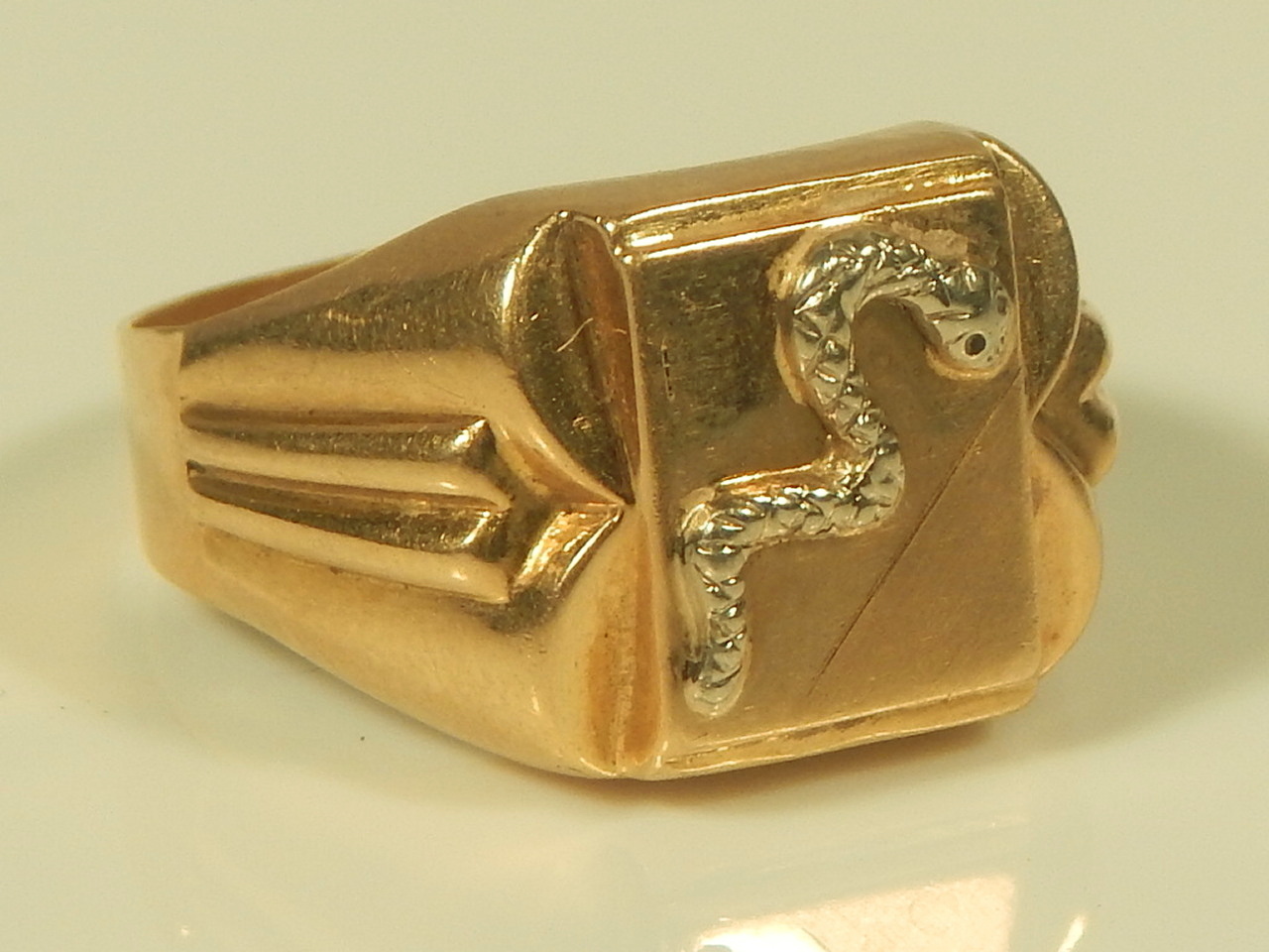 An 18ct gold gentleman's ring, with a white metal snake, 6.3g all in.