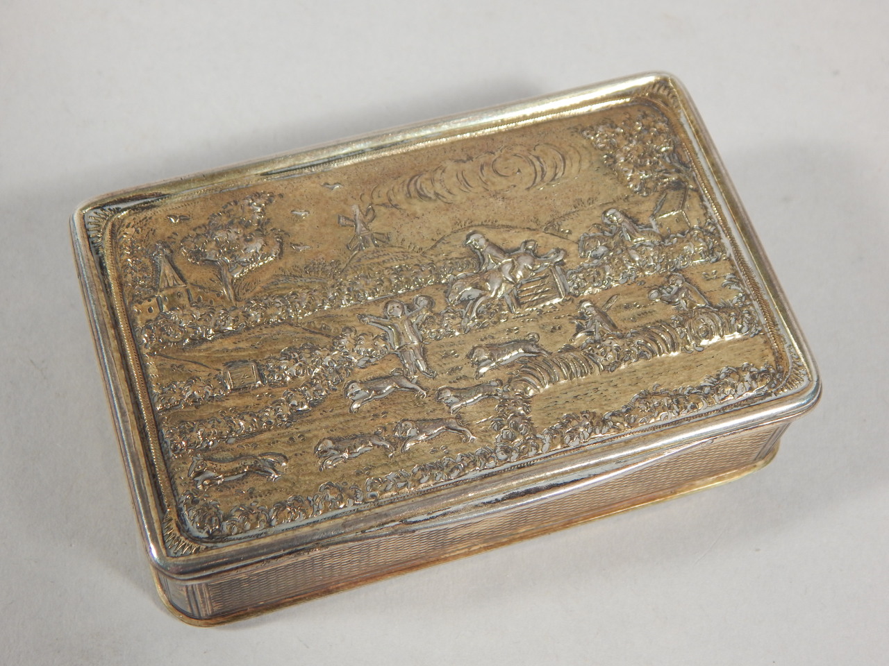 A George IV silver gilt snuff box, the hinged lid decorated with a hunting scene of figures on - Image 2 of 2