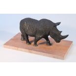 A resin figure, of a standing black rhino, on a slate finish base, of modern construction, 20cm