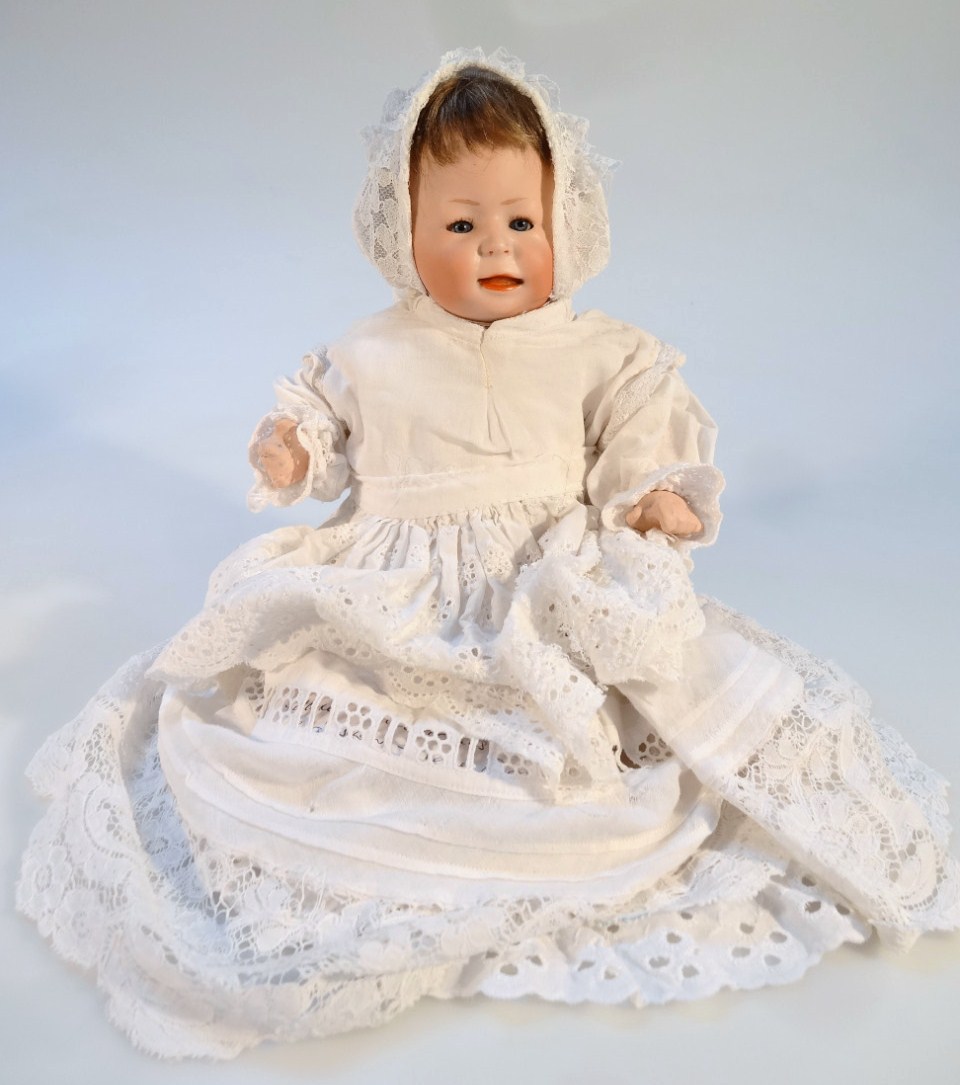 A 19thC German porcelain doll, of small proportion with blonde hair, blue sleep eyes and open mouth,