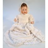 A 19thC German porcelain doll, of small proportion with blonde hair, blue sleep eyes and open mouth,