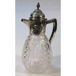 A Victorian silver and cut glass claret jug, with a floral domed lid headed by an acorn finial