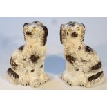 A pair of 19thC Staffordshire spaniels, each with textured bodies and part gilt highlighted collars,