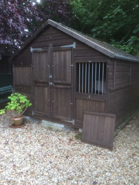 A wooden dog kennel, with separate compartments for two dogs, fitted with interior lights, 200cm